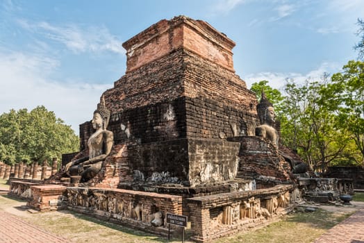 Ruins of a temple with statues of Buddha in Sukhothai Historical Park, thailand