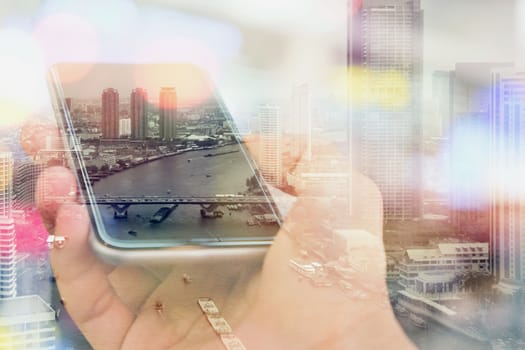 Double exposure image of businessman using smart phone with cityscape background, Business technology concept.