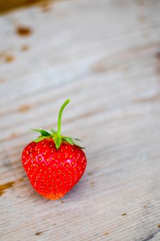 Strawberries red and green on the wood backgrounds