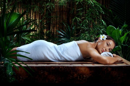 portrait of young beautiful woman relaxing in spa environment.