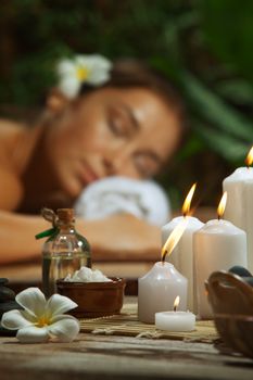 portrait of young beautiful woman in spa environment. Focused on candles