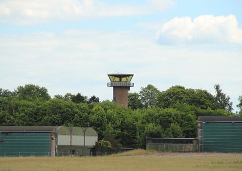 Airfield control tower hidden in forest with clouds