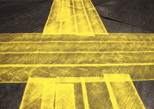 Pattern with grunge yellow cross painted on asphalt