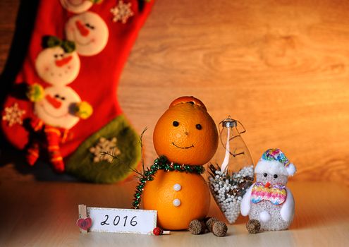 Christmas toy from orange on wood table with sock