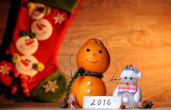 Decoration Orange Snowman on wood table with socks on back