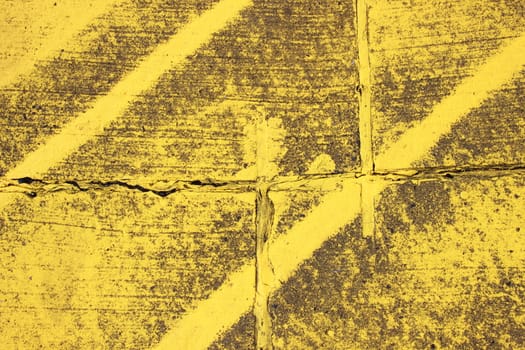 Worn texture with yellow stripes on asphalt