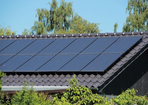 Solar collector on house roof with blue sky