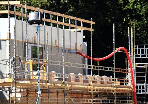 Building site with wooden barrier and red tube