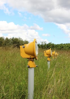 Closeup on runway landing lights in grass field