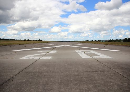 Airplane runway asphalt with number and cross