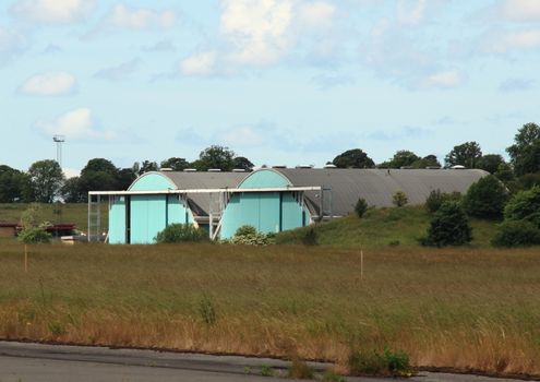 Airplane hangar isolated at airfield with clouds