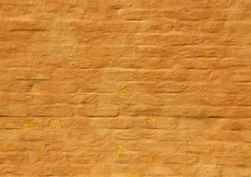 Old ochre yellow painted brick wall background