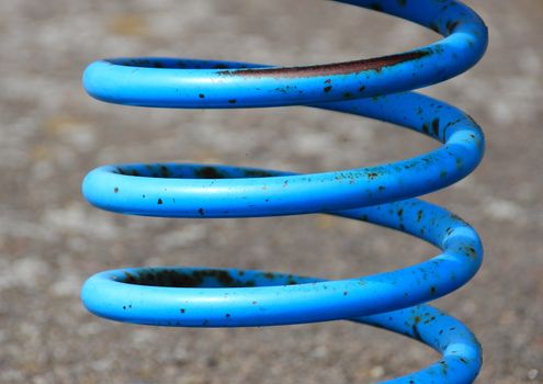 Blue painted metal spring with rust