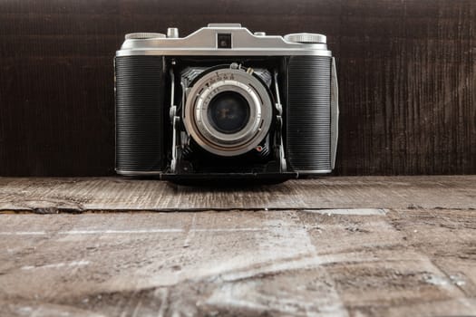 Full vintage bellows camera on a wood background