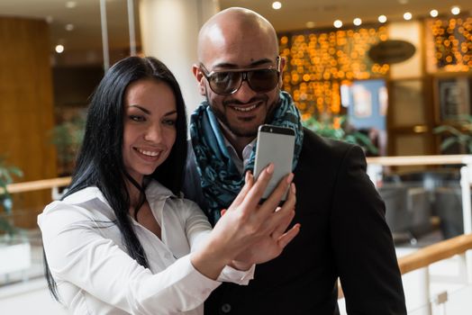 Arab businessman and girl making selfie in the shopping center