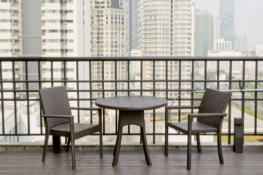 Empty tables and chairs at terrace with high building view