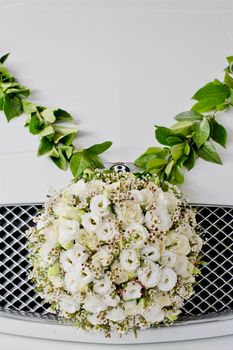 Flower arrangement in ball shape decorate front of front grill of car. The Wedding Flower.