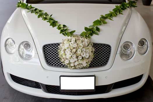 Flower arrangement in ball shape decorate front of front grill of car. The Wedding Flower.