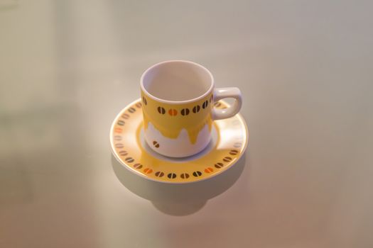 Yellow and white coffee cup decorated over a modern table