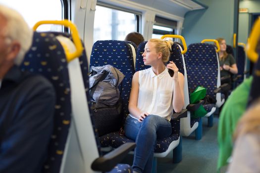 Young woman looking trough window while traveling by train.