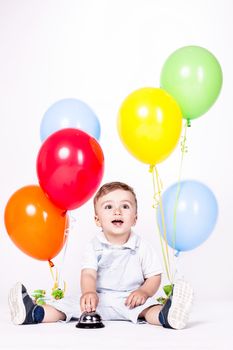 Happy baby boy with bunch of balloons isolated on white