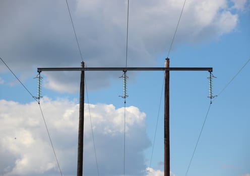 Simple electrical tower in grass field with clouds