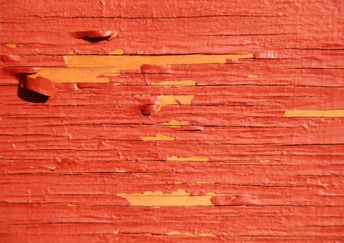 Worn yellow wood with red exfoliated paint