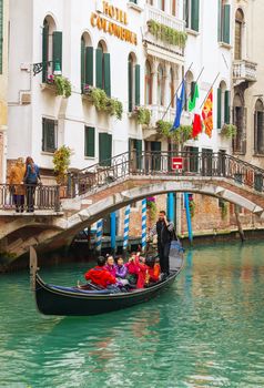 VENICE - NOVEMBER 20: Gondola with tourists on November 20, 2015 in Venice, Italy. The gondola is a traditional, flat-bottomed Venetian rowing boat, well suited to the conditions of the Venetian lagoon.