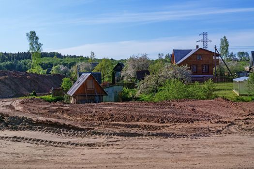 Preparation of the river bank near village for protection against a flood. The road along the construction.