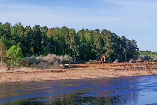 Preparation of the river bank near village for protection against a flood.