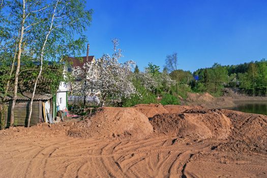 Preparation of the river bank near village for protection against a flood.Cumulative lake for drainage water.Construction of the dam.