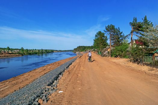 Preparation of the river bank near village for protection against a flood.