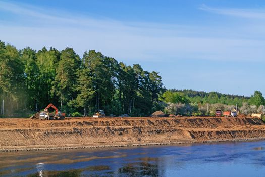 Preparation of the river bank near village for protection against a flood.