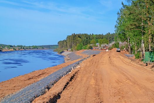 Preparation of the river bank near village for protection against a flood.