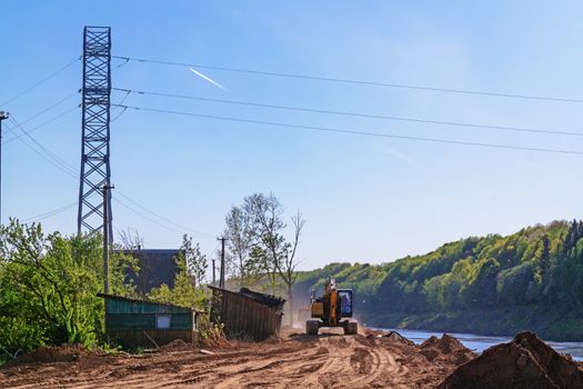 Preparation of the river bank near village for protection against a flood.