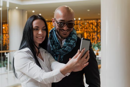 Arab businessman and girl making selfie in the shopping center