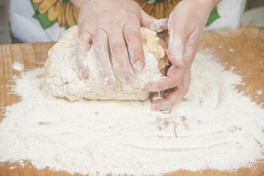 Women's hands preparing fresh yeast dough on wooden table