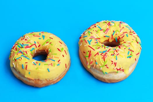 top view of two donuts on blue background