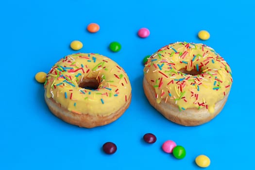 top view of two donuts on blue background