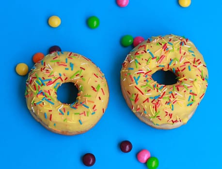 top view of two donuts on blue background