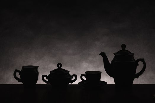 Dark silhouettes of ware for coffee on a gradient non-uniform background