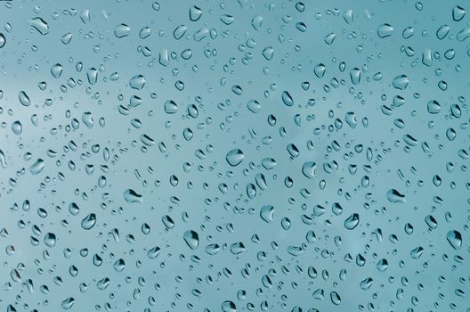Water droplets on the glass with a colored background. Drops of water.
