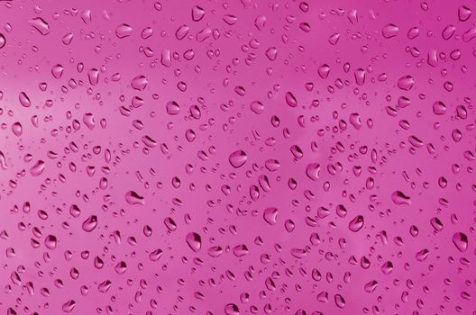 Water droplets on the glass with a colored background. Drops of water.