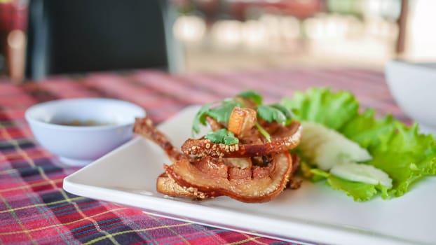 fried pork served with fresh vegetableon white plate , selective focus