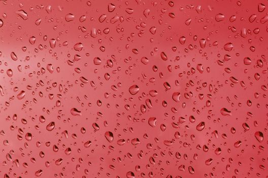 Water droplets on the glass with a colored background. Drops of water.