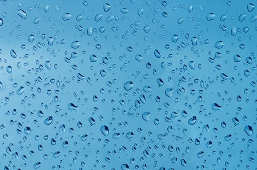 Water droplets on the glass with a colored background. Drops of water.