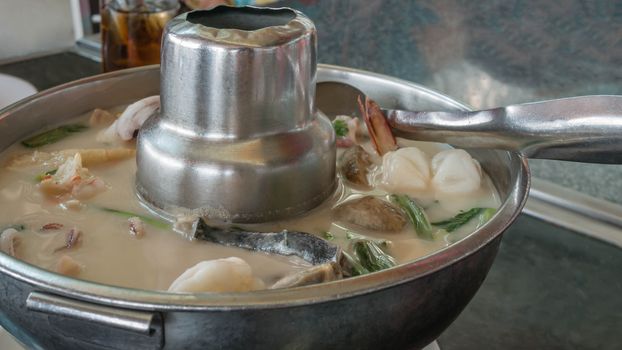 Thai spicy seafood soup in coconut milk ,mushrooms, intensely flavor of galangal, lemongrass, kaffir lime leaf, cilantro
