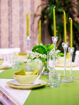 Beautiful table setting with white and green colors. Vertical composition. Shallow DOF