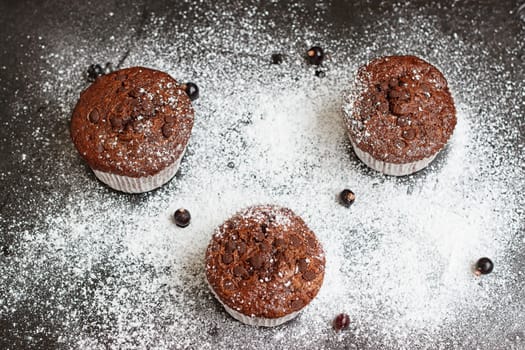 Chocolate cake on a black table with powdered sugar
