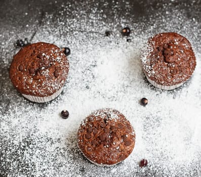 Chocolate cake on a black table with powdered sugar